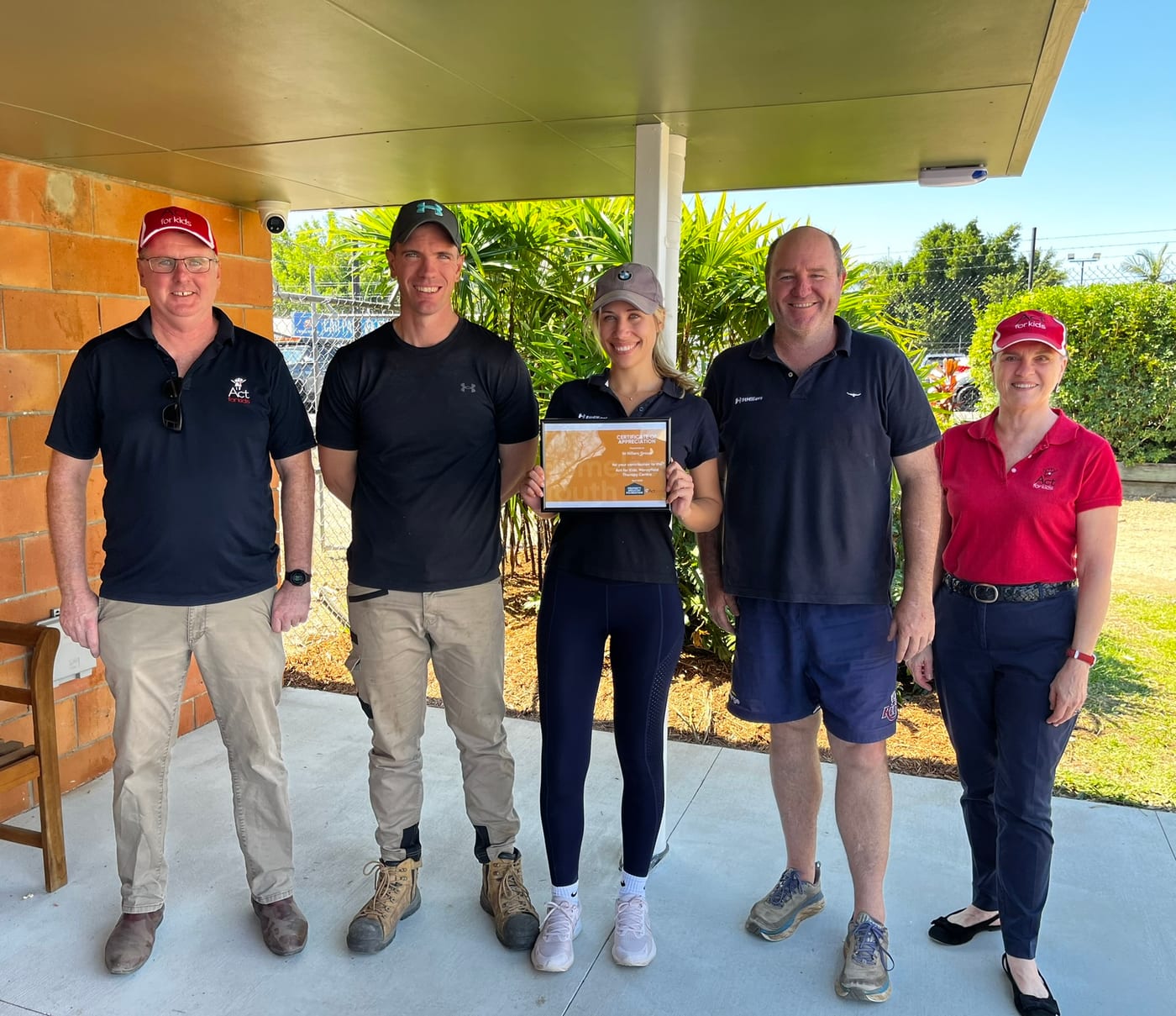 The founders receiving a certificate of appreciation from Act for Kids after a clinic working bee