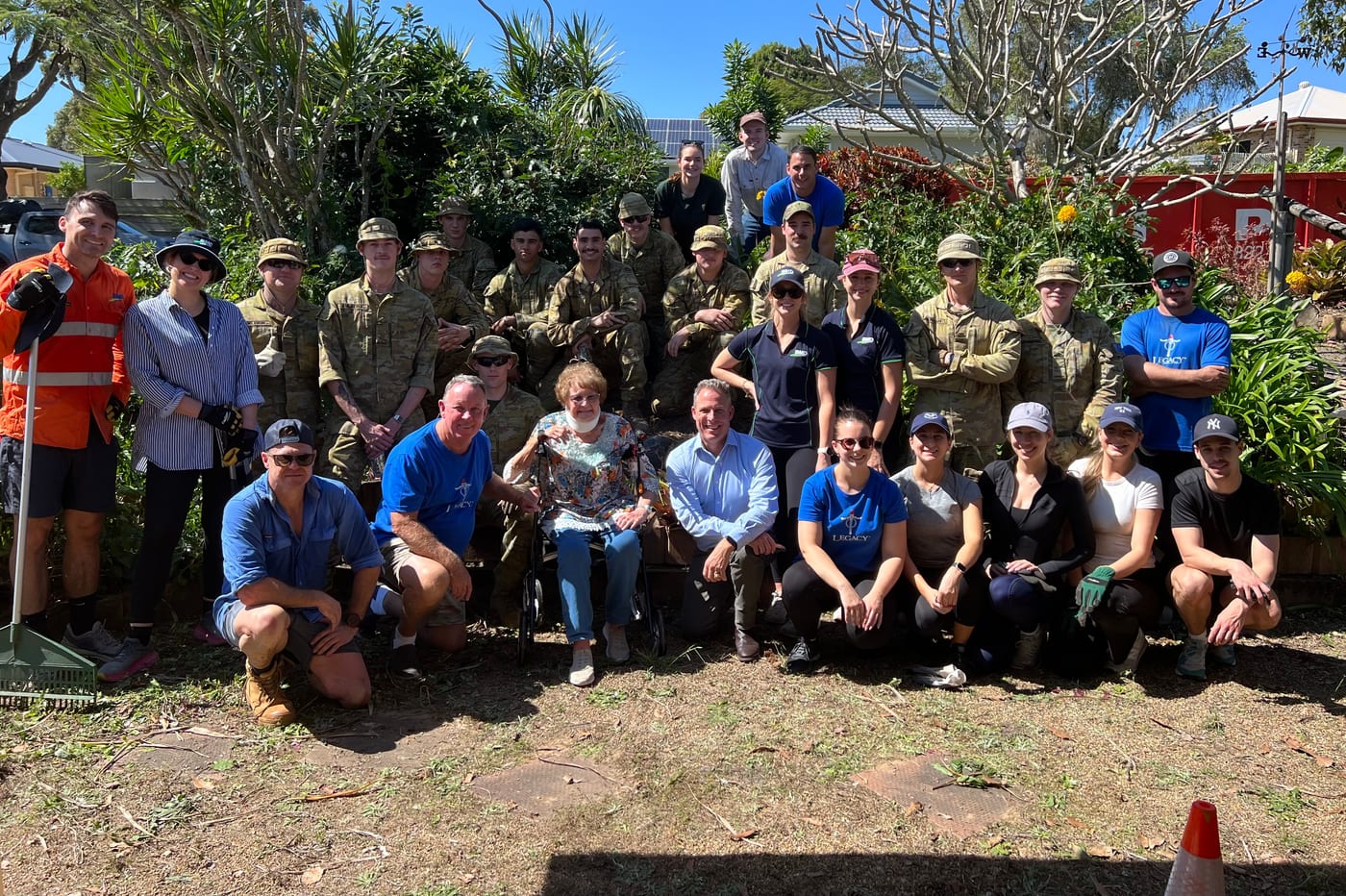 The founders at a backyard blitz alongside ADF personnel, with the elderly homeowner
